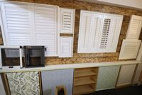 Lot 78 - CONTENTS ON WALL OF SAMPLES OF WHITE SHUTTER BLINDS & ROLLS BLINDS TO LOWER SECTION, & 2x FLY SCREENS (VAT applicable)
